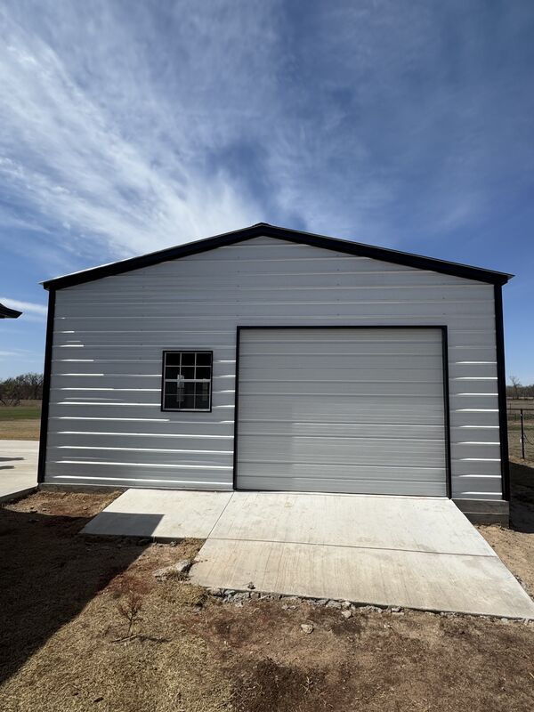 New metal garage building with a roll-up door